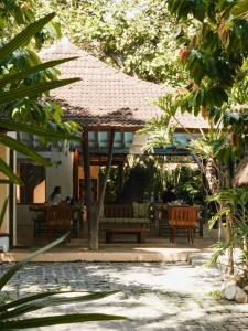 a patio with an umbrella and tables and chairs at Pousada Erva Doce in Arraial d'Ajuda