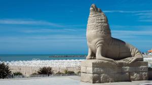a statue of a seal sitting on the beach at Excelente apartamento centrico, a una cuadra de la playa in Mar del Plata