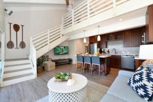 a living room and kitchen with a staircase in a loft at Hoyochi Nikko 201 · HN 201 Relaxing Getaway OceanFront 2BD wPool in Kahana