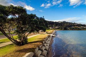 a retaining wall next to a body of water at Sea Views at 7 - Beachside Apartment in Whitianga