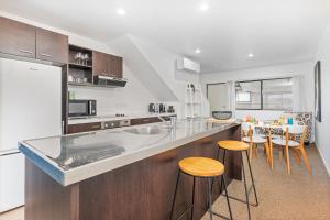 a kitchen with a counter and some stools in it at Sea Views at 7 - Beachside Apartment in Whitianga