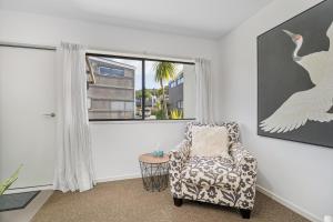 a living room with a chair and a large window at Sea Views at 7 - Beachside Apartment in Whitianga +22 photos