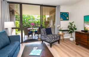 a living room with a couch and a table at Charming Beachside Garden Vistas in Wailea