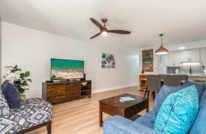 a living room with a couch and a ceiling fan at Charming Beachside Garden Vistas in Wailea