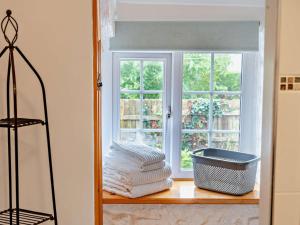 a stack of towels on a shelf in front of a window at 1 Bed in Kidwelly 43406 in Kidwelly +13 photos