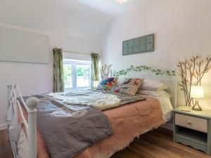 un dormitorio con una cama y una ventana en 3 Bed in South Molton 78305, en Kings Nympton