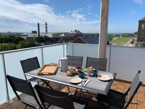 ein Tisch auf einem Balkon mit Blick auf die Stadt in der Unterkunft Les Terrasses du Phare, vue mer, 100m plage, pkg, terrasses, accès PMR in Berck-sur-Mer