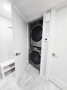 un lavadero con lavadora y secadora en Entire Superior 2-bedroom private suite, en Edmonton