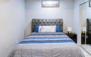 1 dormitorio con 1 cama grande de color azul y blanco en Entire Superior 2-bedroom private suite, en Edmonton