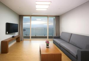 a living room with a couch and a television at Goheung Sun Valley Resort in Goheung