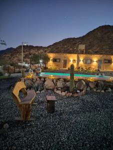 un patio con una casa, una piscina y un banco en cabañas vistas de Cafayate, en Cafayate