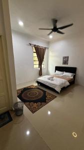 a bedroom with a bed and a ceiling fan at Cwa Homestay in Kampong Molek
