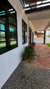 a porch of a house with a brick patio at Cwa Homestay in Kampong Molek