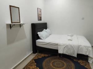 a bedroom with a bed with a mirror and a rug at Cwa Homestay in Kampong Molek