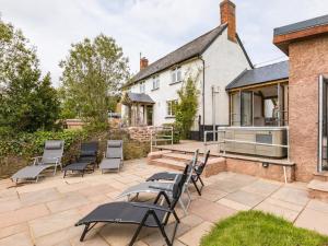 a patio with chairs and a house at 6 Bed in Cadeleigh 66780 in Cadeleigh