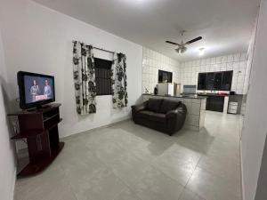 ein Wohnzimmer mit Sofa und Fernseher in der Unterkunft Casa, Boqueirão Norte em Ilha Comprida- SP in Ilha Comprida
