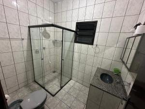 ein Badezimmer mit Dusche, Toilette und Waschbecken in der Unterkunft Casa, Boqueirão Norte em Ilha Comprida- SP in Ilha Comprida + 15 Fotos