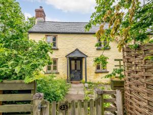 a yellow house with a wooden fence in front of it at 3 Bed in Clyro 88077 in Clyro