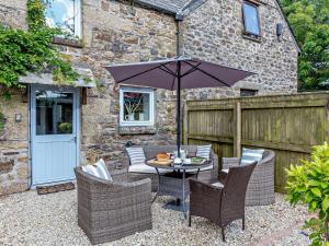 a patio with a table and chairs with an umbrella at 3 Bed in Lanhydrock 90217 in Bodmin