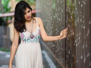 une femme en robe blanche debout à côté d'une clôture dans l'établissement Novotel Goa Resort & Spa Candolim, à Candolim