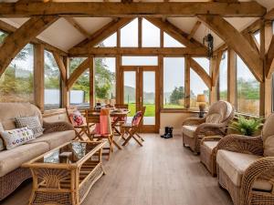 a living room with couches and tables and windows at 4 Bed in New Quay 78801 in Llandyssiliogogo