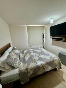 une chambre avec un lit avec une couette dessus dans l'établissement Lindo y cómodo apartamento en Santiago centro, à Santiago