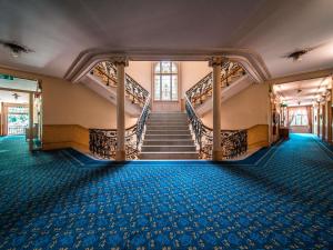a staircase in a building with blue carpet at Royal St. Georges Hotel Interlaken - MGallery Collection in Interlaken