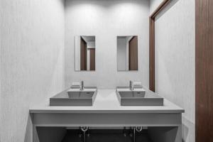 a bathroom with two sinks and two mirrors at The Arklune in Sapporo