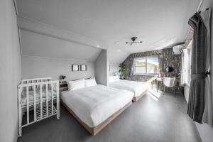 a bedroom with two beds and a bathroom with a sink at The Arklune in Sapporo