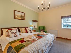a bedroom with a large bed and a chandelier at 1 Bed in Edzell CA335 in Edzell