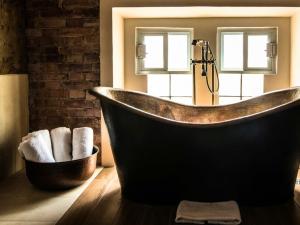 a bathroom with a copper tub and a mirror at Hotel Santosi in San Luis Potosí +74 photos
