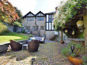 a house with a brick patio with furniture in front of it at 4 Bed in Conwy 50934 in Tal-y-Cafn