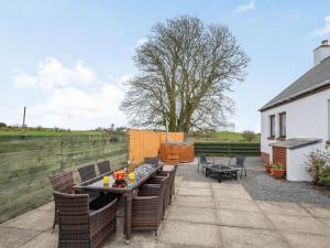 a patio with a table and chairs and a fence at 3 Bed in Port William 87541 in Mochrum +8 photos