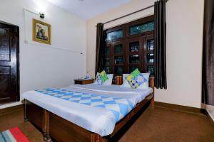 ビムタルにあるHotel O Maha Maya Inn Home Stayの窓のある大きなベッドのある寝室