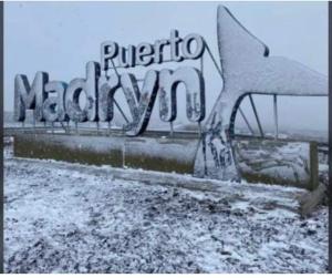 ein Schild mit der Aufschrift „Puerto Mogan“ und Schnee darauf in der Unterkunft Loid Patagonia in Puerto Madryn + 2 Fotos