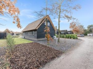 una pequeña casa con techo de paja en Modern bungalow in Baarle-Nassau with pond view, en Schaluinen