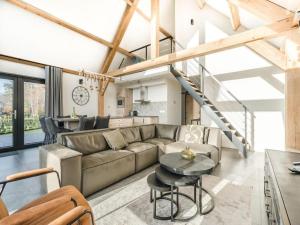 una sala de estar con un sofá y una mesa en Modern bungalow in Baarle-Nassau with pond view, en Schaluinen