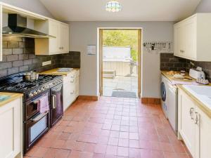 a kitchen with white cabinets and a stove top oven at 2 Bed in Aberaeron 45333 in Aberaeron