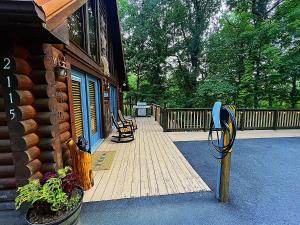 a porch of a house with two chairs on a deck at Wonderland Cabin in Sevierville