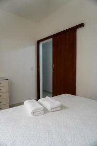 a bedroom with two towels on a bed with a mirror at Apartamento Baixu 1 in Prado