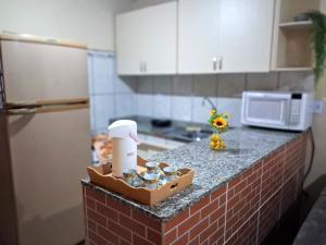 a kitchen counter with a mixer and cups on it at Casa com Piscina no Centro de Unamar em Cabo Frio in Cabo Frio +1 photo