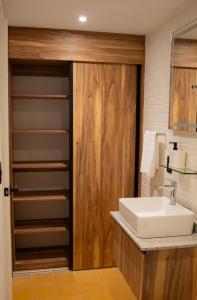 a bathroom with a sink and a wooden door at Calle y Número, López Cotilla in Guadalajara