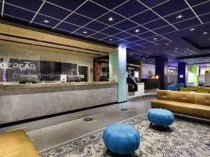 Un vestíbulo con un bar con taburetes azules. en ibis budget Porto Alegre - Super Econômico, en Porto Alegre