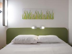 1 cama con cabezal verde y 2 almohadas en ibis budget Porto Alegre - Super Econômico, en Porto Alegre 79 fotos más