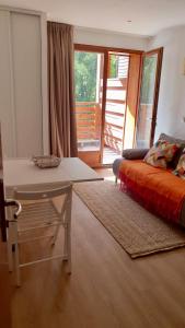 - une chambre avec un lit, une table et un balcon dans l'établissement Cozy 1B apartment at the foot of the slopes, à Guillaumes