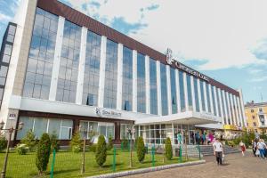 a large building with people walking in front of it at Snowy Owl Hotel in Krasnoyarsk