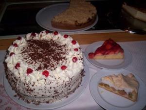 una mesa con un pastel y tres platos de postres en Landgasthaus zum Engel, en Freiamt