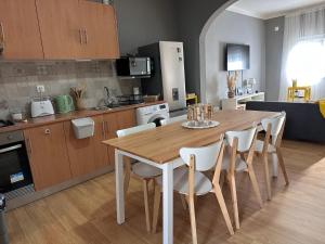 a kitchen with a wooden table and white chairs at Casinha de Galveias in Galveias