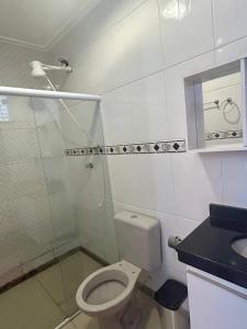 a white bathroom with a toilet and a sink at Apê VistaBella seu refúgio no Caparaó in Alto Caparao +3 photos