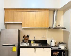 a kitchen with a sink and a refrigerator at Modern 2br Unit in Davao in Davao City